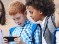 Des enfants utilisant un téléphone. // Source : Canva